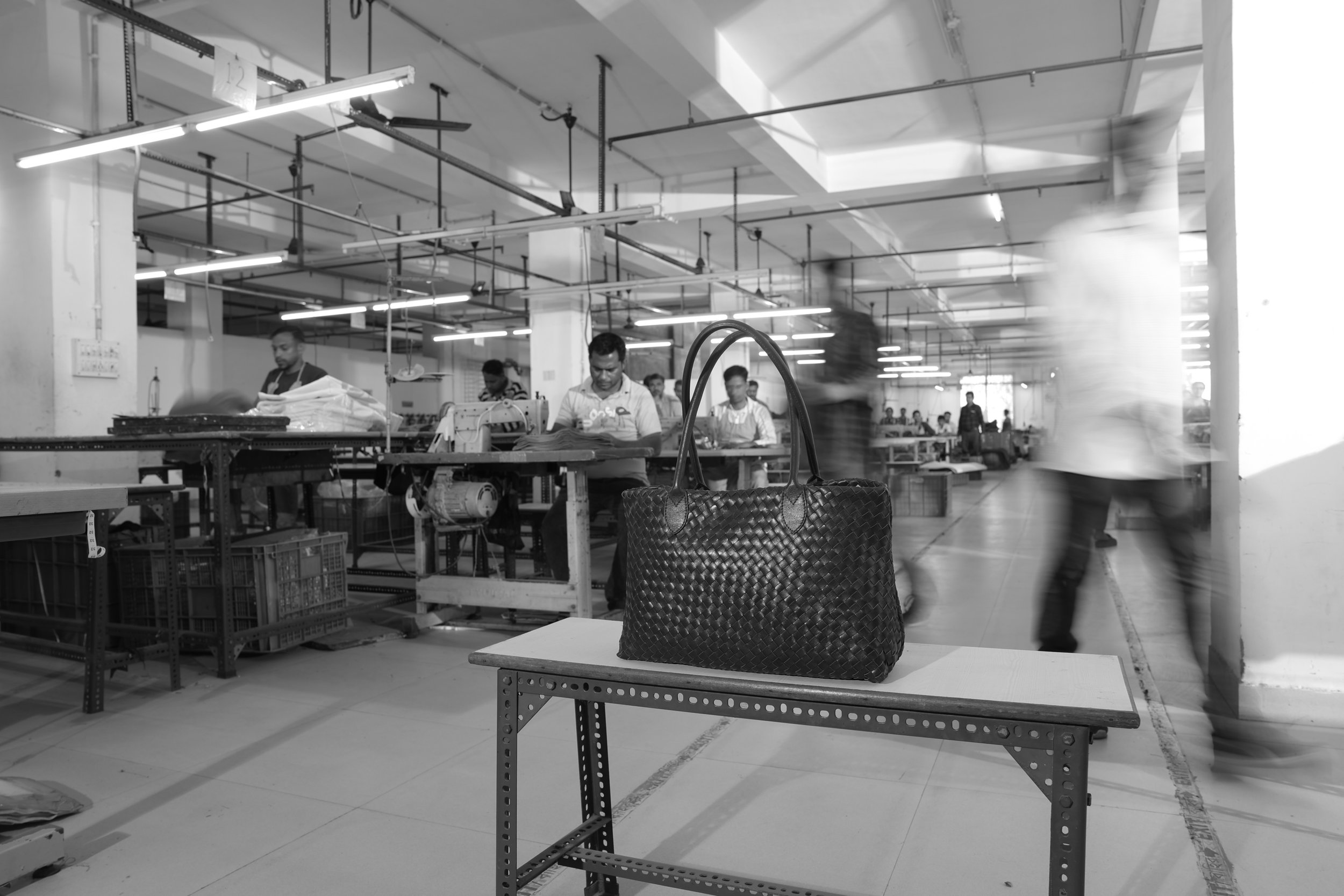 Leather product line on assembly table inside Kolkata workshop